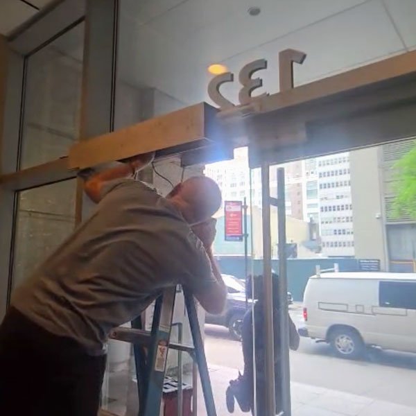 The technician is fixing the entrance door